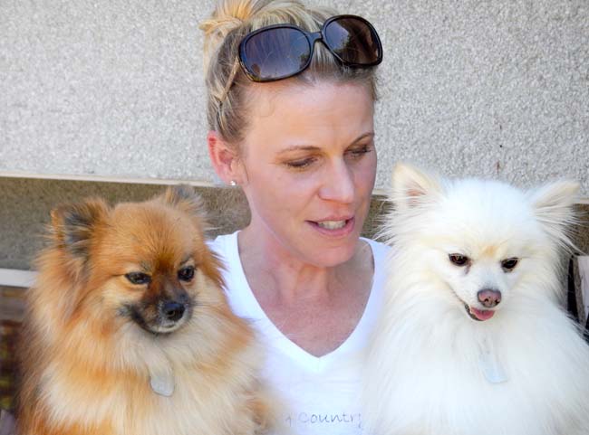Dog rescuer Dori McRae cuddles two of the dogs she's looking for homes for.